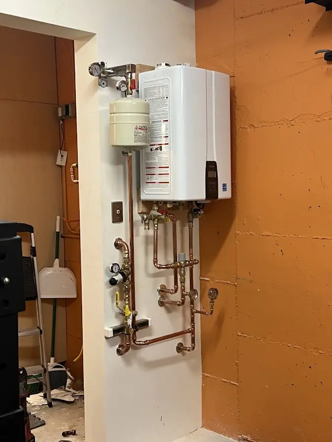 Plumbing technician inspecting water heater connections in Ephraim